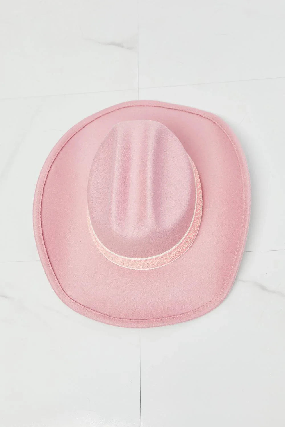 Pastel pink cowgirl hat with adjustable straps and tribal print detailing