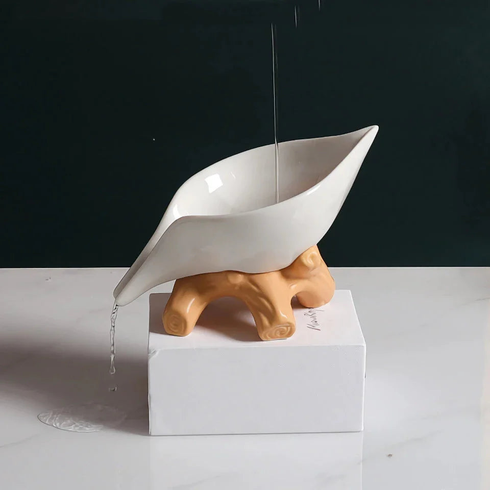 Elegant ceramic leaf-shaped soap holder with a sturdy base, adding a touch of nature-inspired sophistication to any bathroom