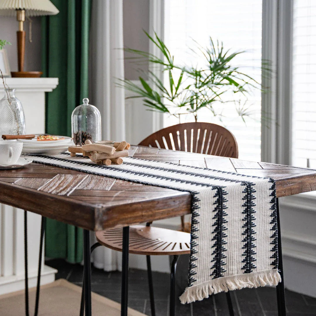 Elegant black and white cotton table runner with classic striped pattern and tassels, perfect for sophisticated dining decor