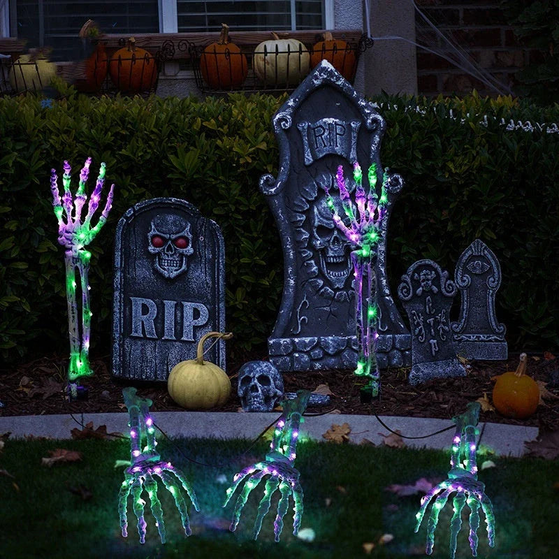 Solar-powered Halloween ground lamp with hand-shaped LED lights in purple and green colours, creating a spooky ambience in an outdoor courtyard