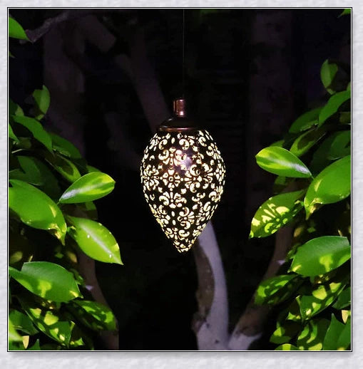 Decorative outdoor solar lanterns hanging in a lush garden, providing warm, ambient lighting