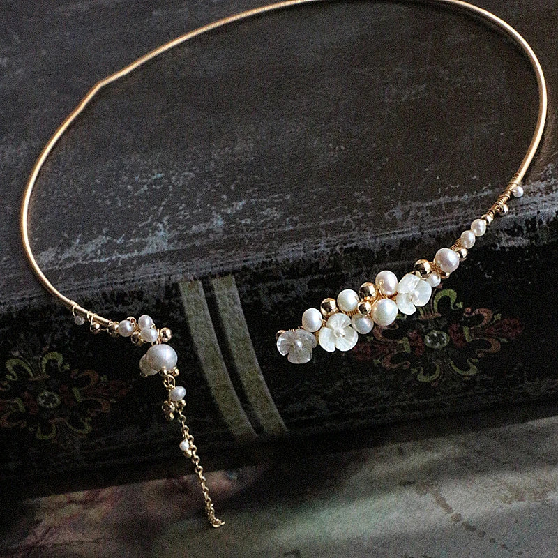 Elegant handcrafted clavicle necklace made of natural pearl shell with an intricate floral pattern, a timeless British design accessory.