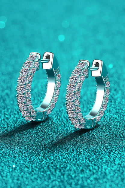 Pair of elegant sterling silver huggie earrings adorned with dazzling moissanite stones, showcasing a minimalist and sophisticated design.
