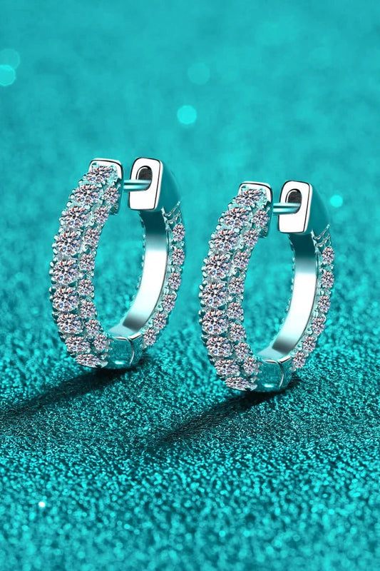 Pair of elegant sterling silver huggie earrings adorned with dazzling moissanite stones, showcasing a minimalist and sophisticated design.