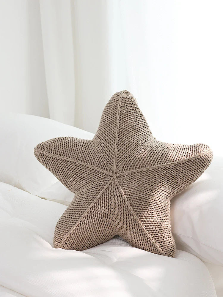Artfully hand-knitted starfish-shaped cushion in a range of sophisticated colour options, providing plush comfort and coastal charm for any living space.