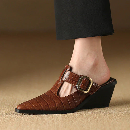 Elegant black leather wedge mules with a chic buckle detail, providing comfort and style for every occasion.