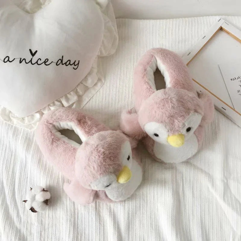 Pair of cosy, plush home slippers featuring a playful penguin design