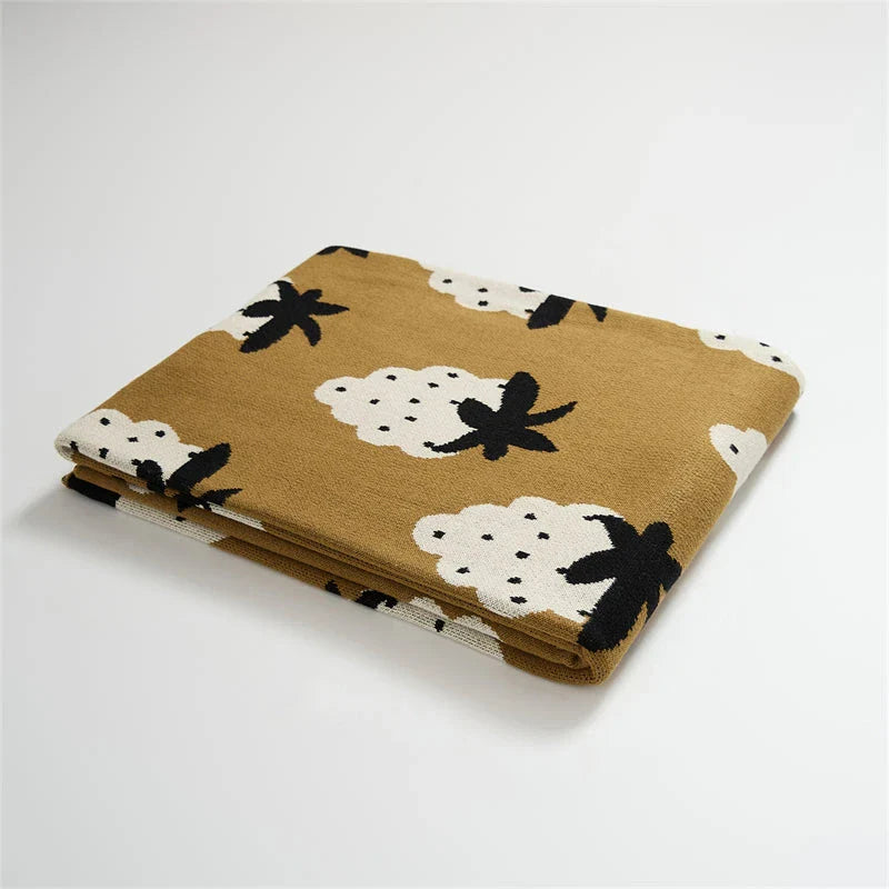A cosy grape-patterned cotton blanket with a sophisticated design, perfect for relaxation and home decor