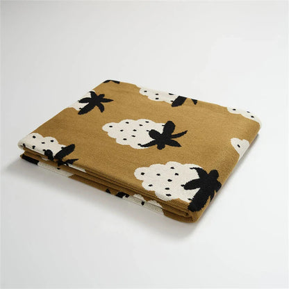 A cosy grape-patterned cotton blanket with a sophisticated design, perfect for relaxation and home decor
