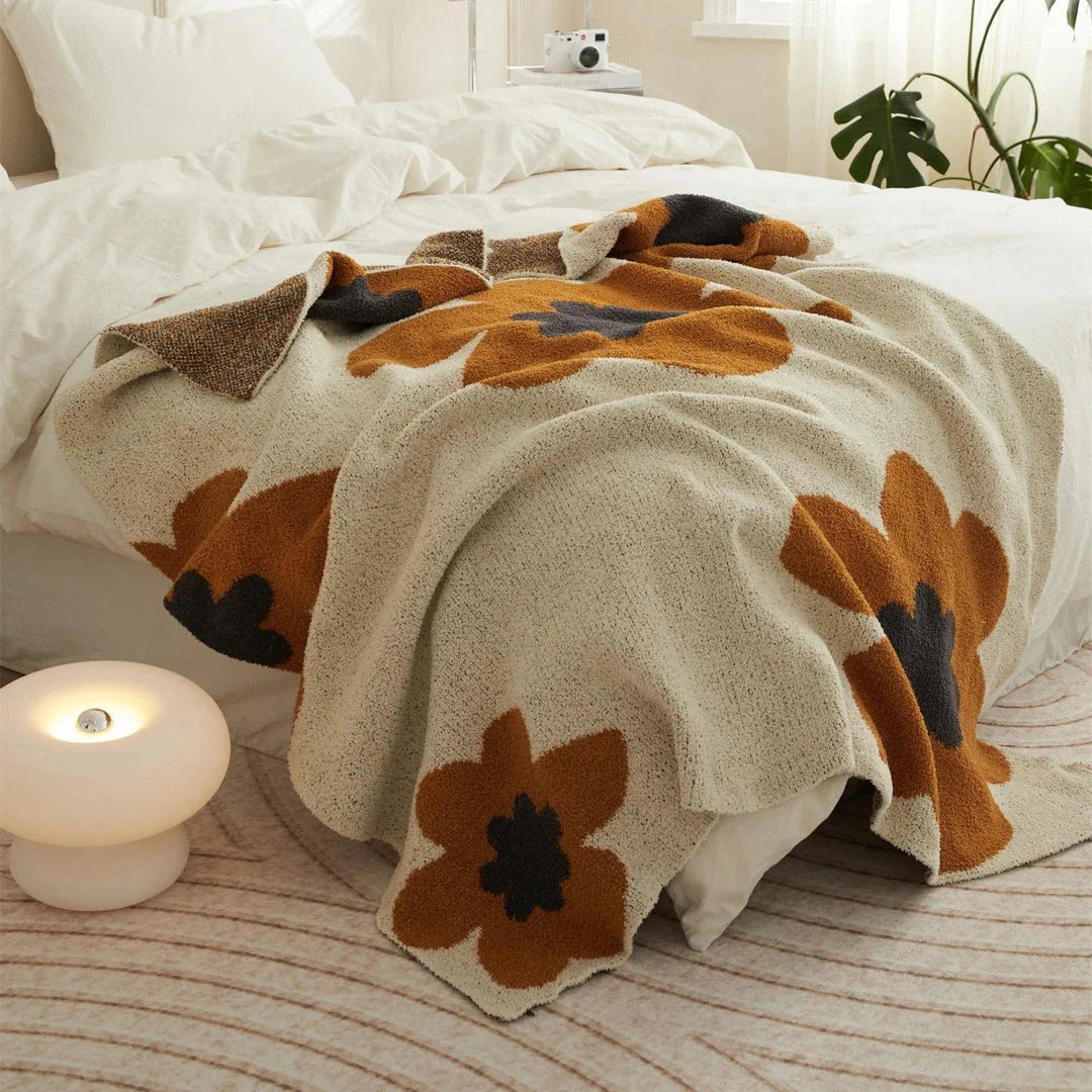 Cosy floral knitted throw blanket in red, grey, and orange shades - a high-quality microfibre accessory for year-round comfort and style