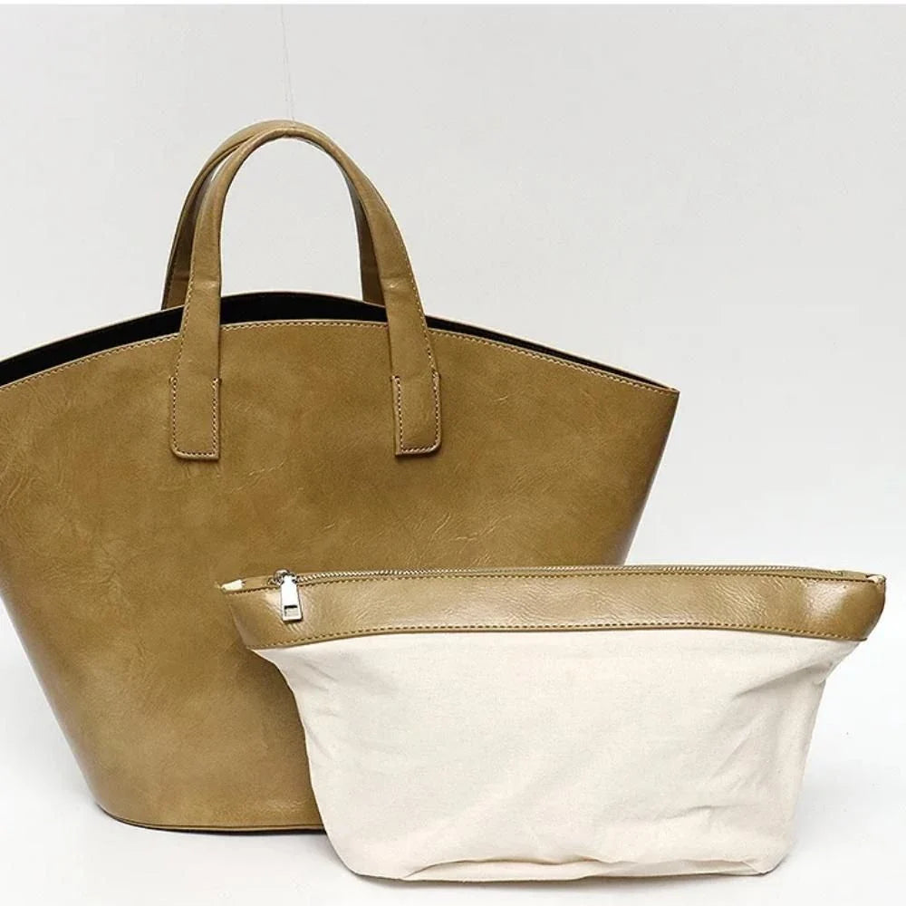 Elegant vegan leather tote bag with a unique bucket shape, short handles, and long straps for versatile carrying options