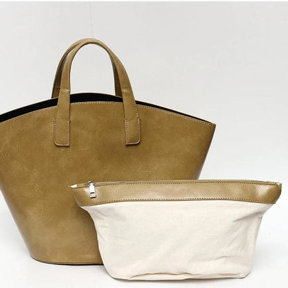 Elegant vegan leather tote bag with a unique bucket shape, short handles, and long straps for versatile carrying options