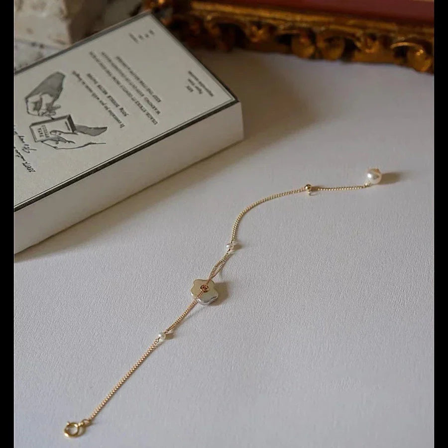 Elegant 14K gold-plated bracelet adorned with shimmering freshwater pearls, a timeless British-inspired accessory.