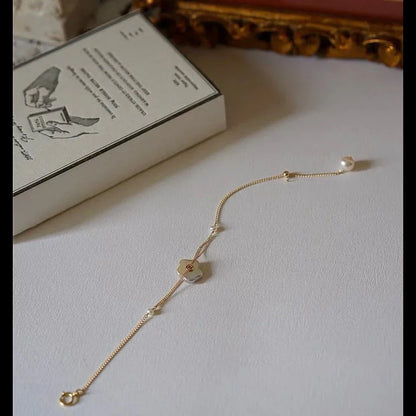 Elegant 14K gold-plated bracelet adorned with shimmering freshwater pearls, a timeless British-inspired accessory.