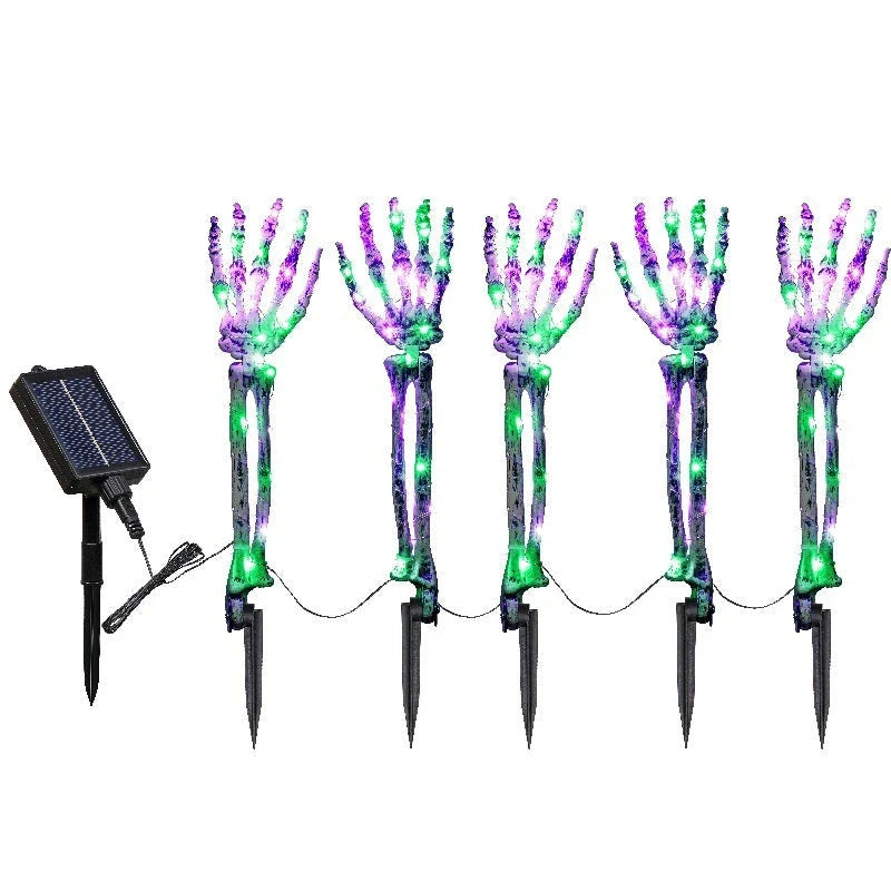 Solar-powered Halloween ground lamp with hand-shaped LED lights in purple and green colours, creating a spooky ambience in an outdoor courtyard