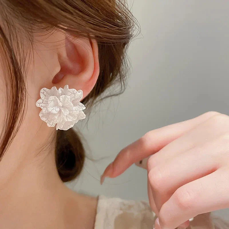 Elegant white floral stud earrings with a unique and captivating design, perfect for fashion-forward women in the UK