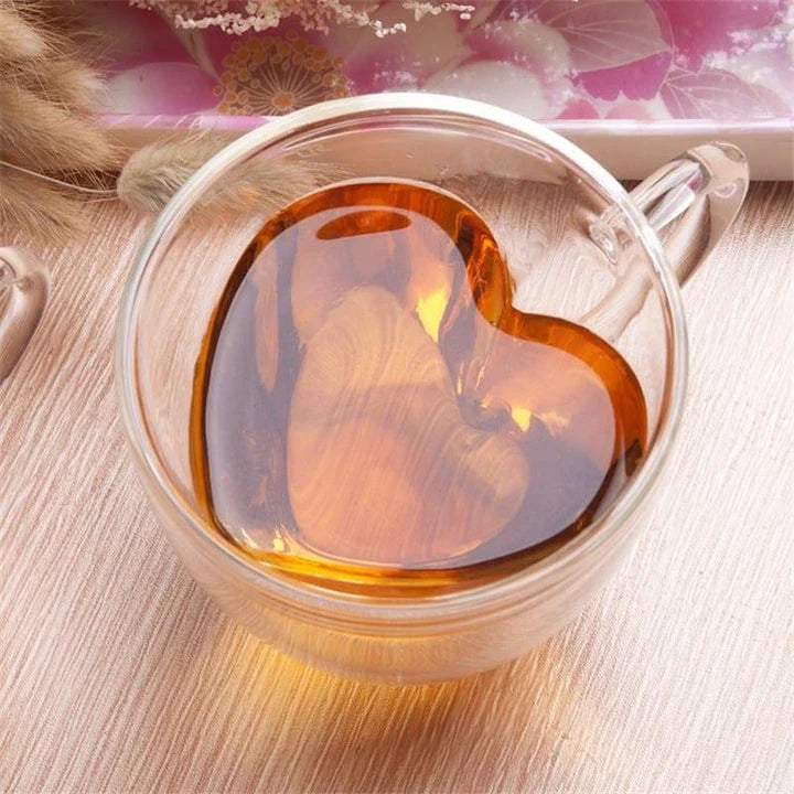 A charming heart-shaped ceramic mug with a smooth, glossy finish, perfect for enjoying hot beverages like tea or coffee.