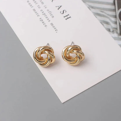 Elegant geometric statement earrings with a luxurious gold finish, featuring a unique hollow twist design.