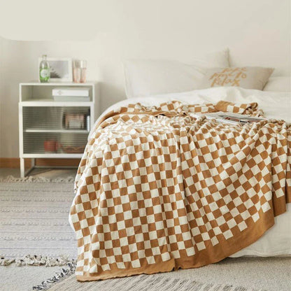 Cosy checkerboard plaid cotton knitted blanket in earthy tones of green, khaki, and black for stylish home decor