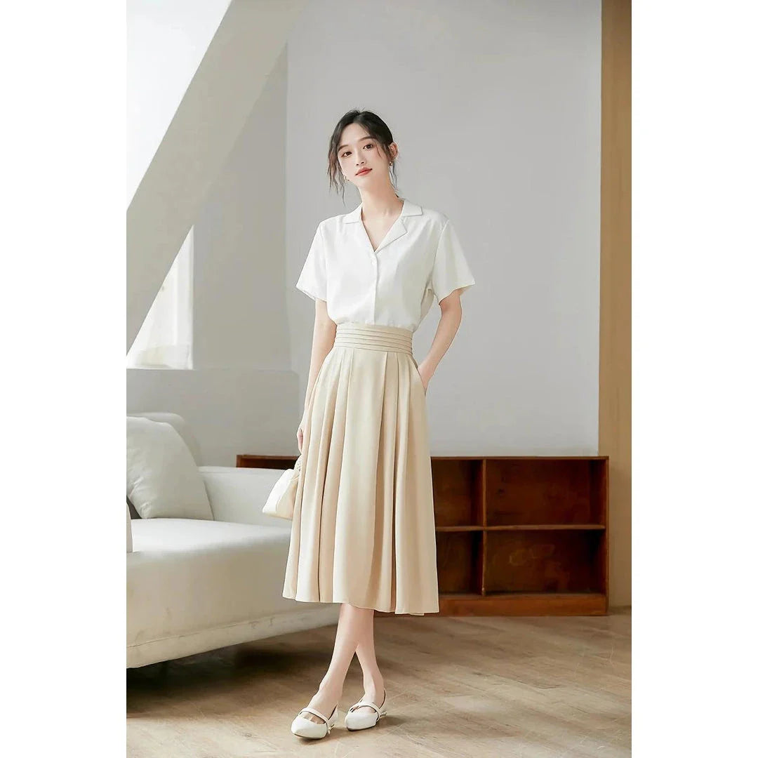 Elegant high-waisted pleated skirt with pockets in apricot colour, made from a blend of acrylic, cotton, and polyester for comfort and durability.