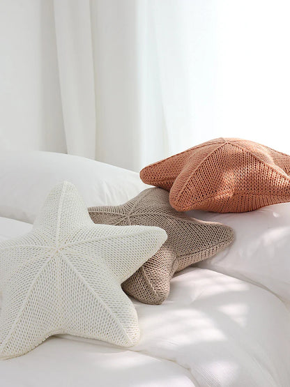 Artfully hand-knitted starfish-shaped cushion in a range of sophisticated colour options, providing plush comfort and coastal charm for any living space.