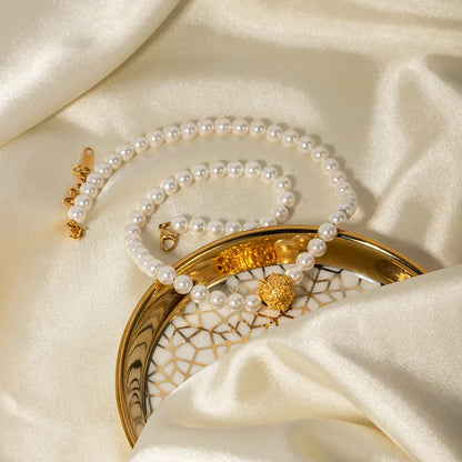 An elegant 18K gold-plated stainless steel bracelet featuring a flower ball design with a lustrous pearl centre