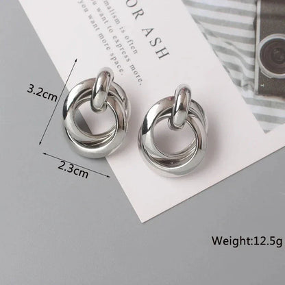 Elegant geometric statement earrings with a luxurious gold finish, featuring a unique hollow twist design.