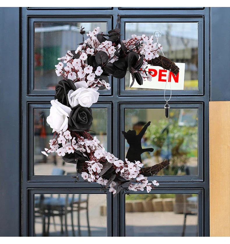 Spooktacular Halloween garland featuring a blend of dried white flowers, black roses, and mystical moon cat ornaments