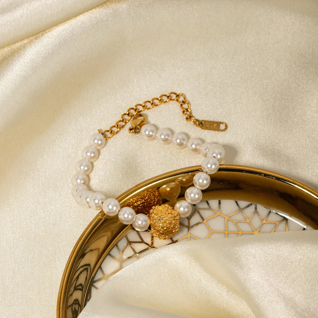 An elegant 18K gold-plated stainless steel bracelet featuring a flower ball design with a lustrous pearl centre