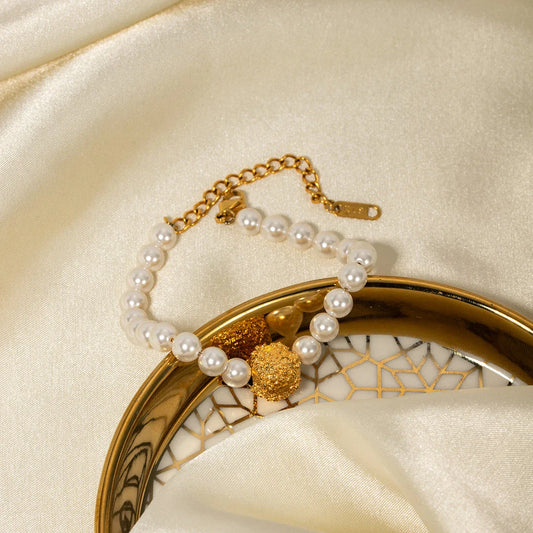 An elegant 18K gold-plated stainless steel bracelet featuring a flower ball design with a lustrous pearl centre
