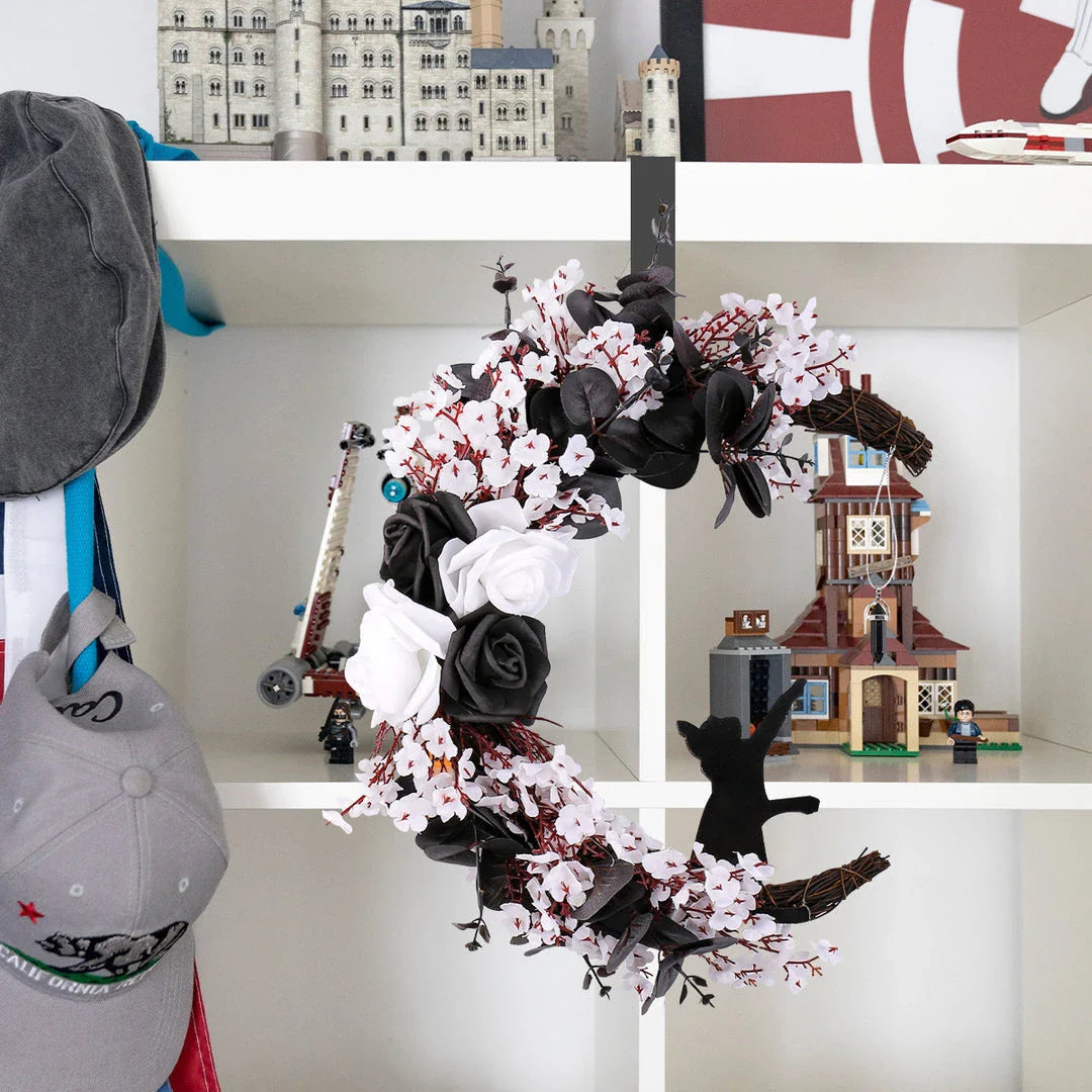 Spooktacular Halloween garland featuring a blend of dried white flowers, black roses, and mystical moon cat ornaments