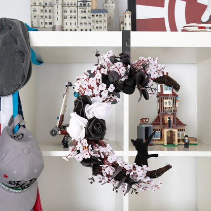 Spooktacular Halloween garland featuring a blend of dried white flowers, black roses, and mystical moon cat ornaments