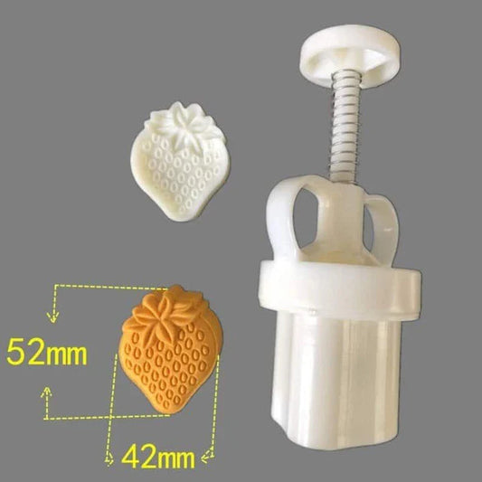 A white strawberry-shaped chocolate stamp used for decorating homemade chocolates, cookies, and baked goods
