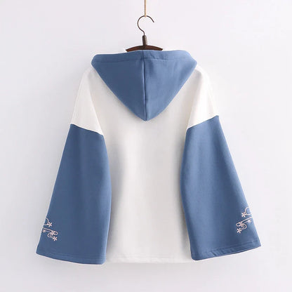 A cosy, velvet-padded hooded sweater with playful alphabet sleeves in pink and blue colours
