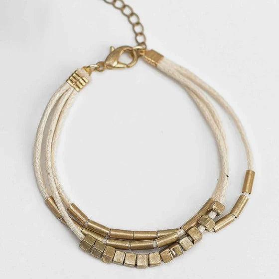 Elegant layered bracelet with beige leather and gold-coloured beads, a versatile accessory for modern British style