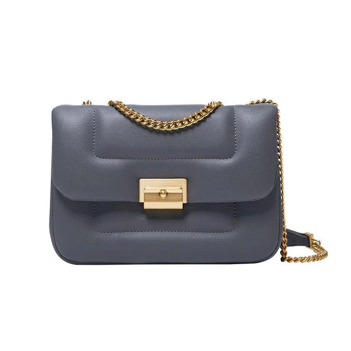 Grey leather crossbody bag with adjustable metal shoulder strap and secure hasp closure