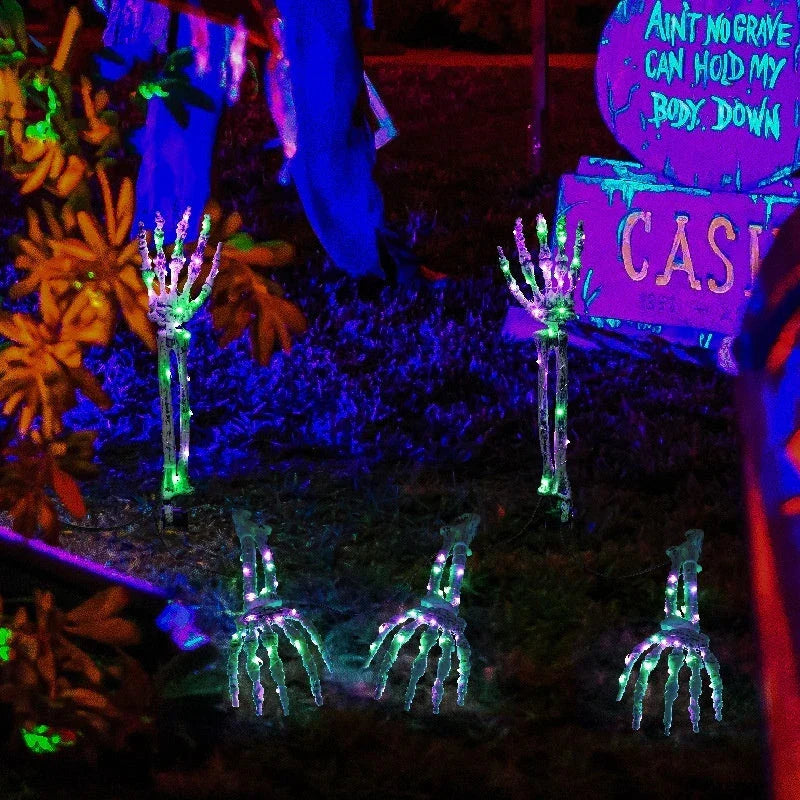 Solar-powered Halloween ground lamp with hand-shaped LED lights in purple and green colours, creating a spooky ambience in an outdoor courtyard