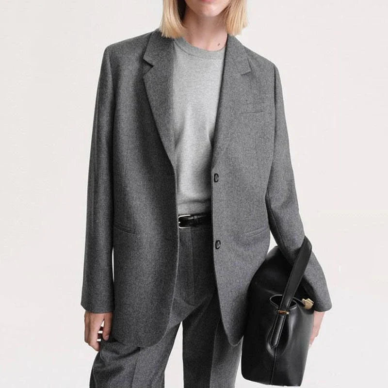 Elegant and refined women's woollen blazer with a wide-waisted silhouette, single-breasted closure, and turn-down collar