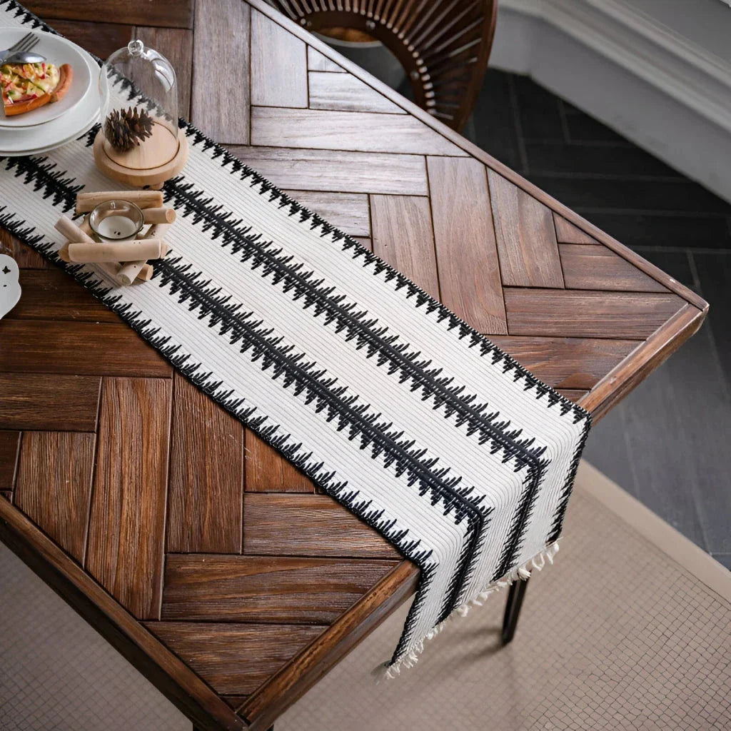 Elegant black and white cotton table runner with classic striped pattern and tassels, perfect for sophisticated dining decor