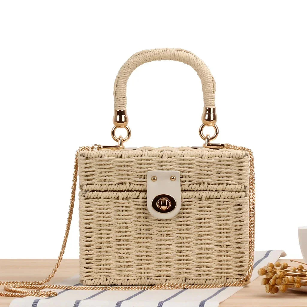 Handcrafted natural straw beach bag with bohemian-inspired design and detachable metal chain strap