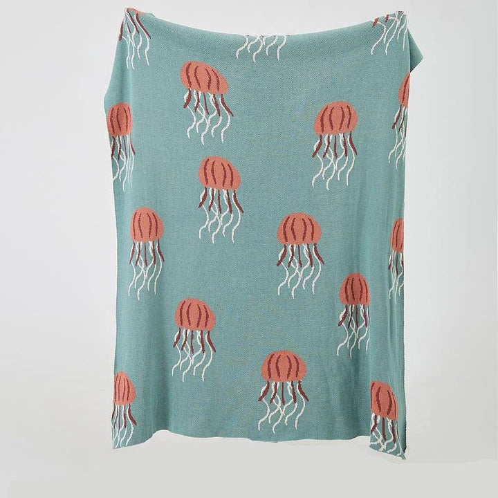 Cosy jellyfish-patterned cotton knit throw blanket in green and grey colours, showcasing its soft, plush texture and unique design.