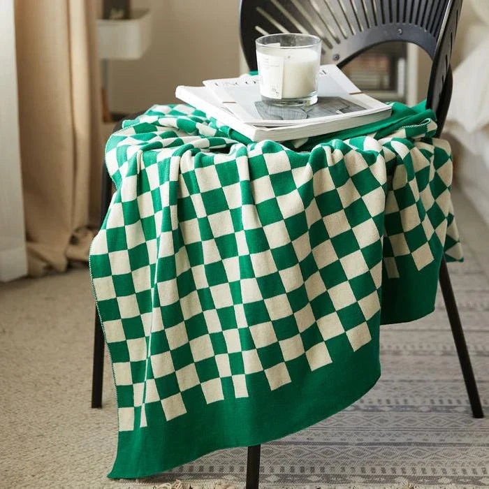 Cosy checkerboard plaid cotton knitted blanket in earthy tones of green, khaki, and black for stylish home decor