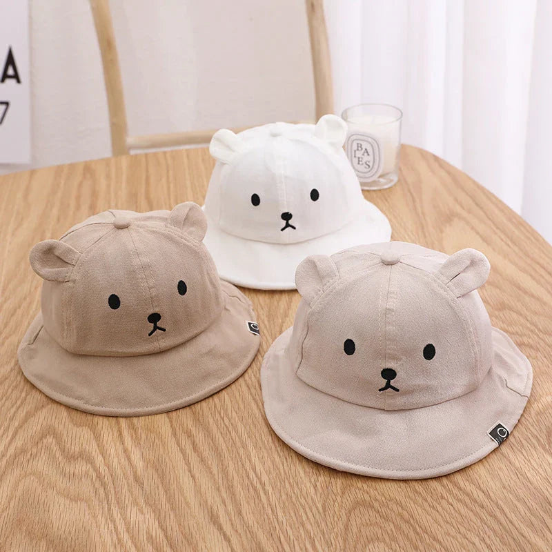 Adorable baby sun hat with cute bear ears, made of soft cotton and durable polyester for sun protection and comfort.