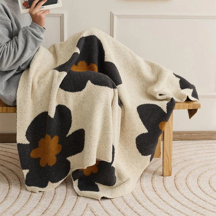 Cosy floral knitted throw blanket in red, grey, and orange shades - a high-quality microfibre accessory for year-round comfort and style