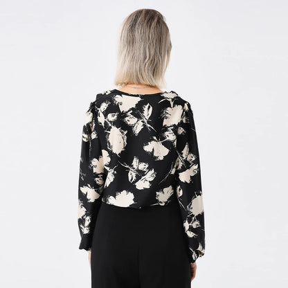 Elegant ladies' blouse with a printed pattern, dropped collar, and long sleeves in a classic white colour