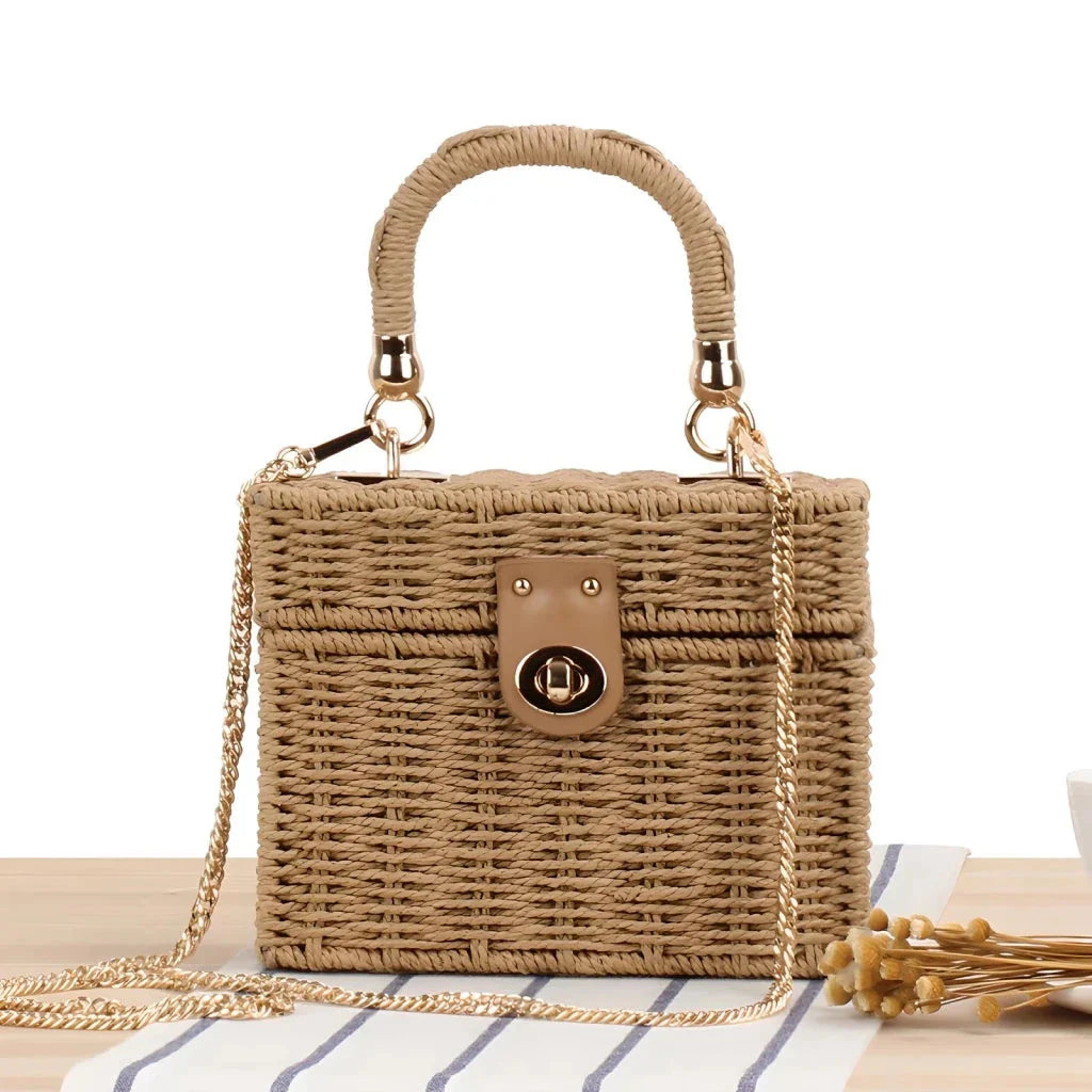 Handcrafted natural straw beach bag with bohemian-inspired design and detachable metal chain strap