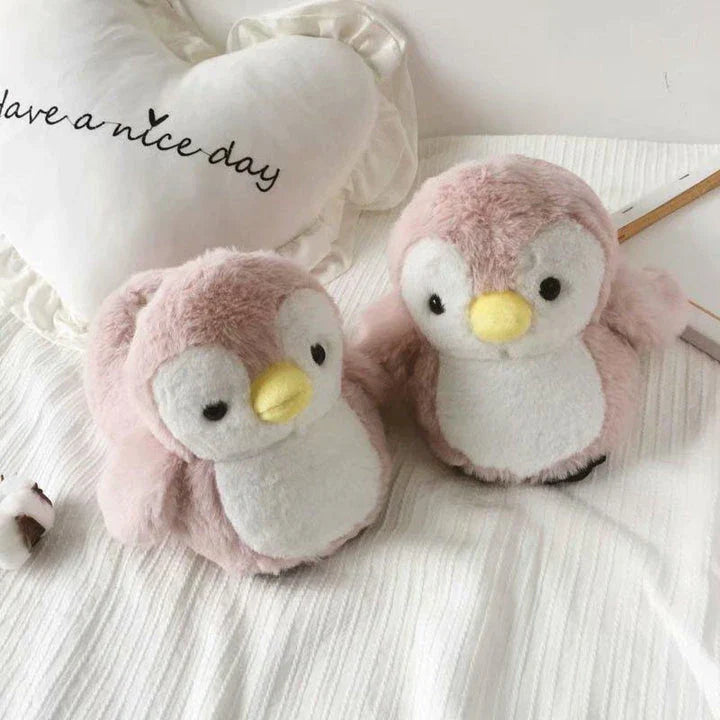 Pair of cosy, plush home slippers featuring a playful penguin design