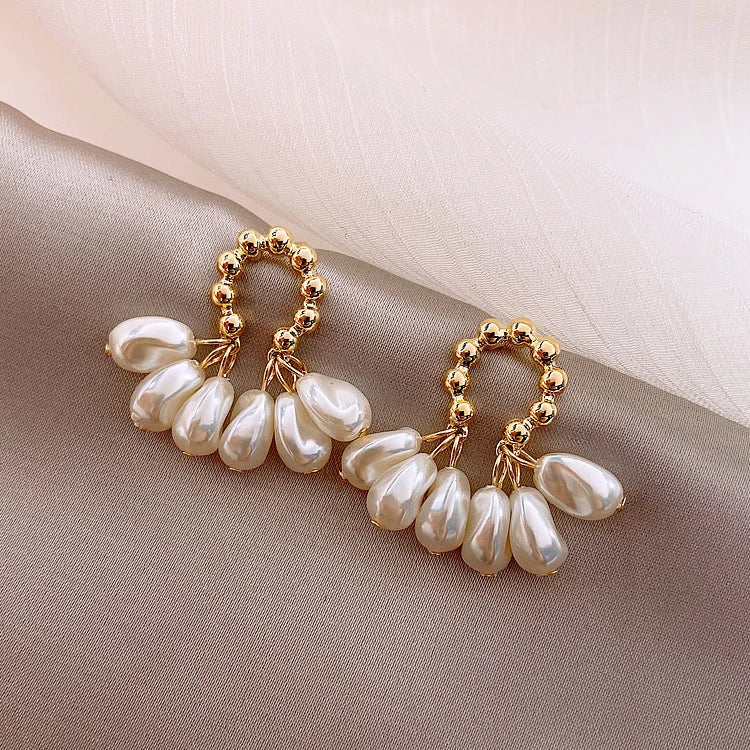 Pair of elegant Baroque-inspired pearl earrings with a silver and gold plated alloy setting