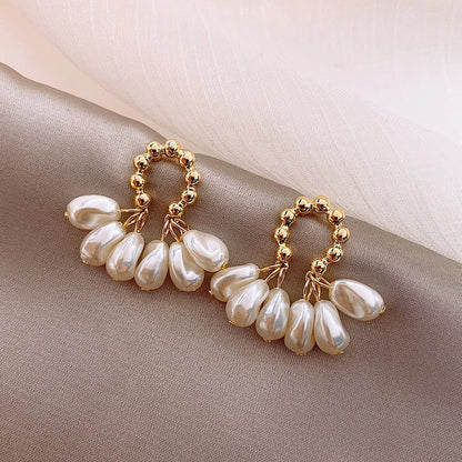 Pair of elegant Baroque-inspired pearl earrings with a silver and gold plated alloy setting