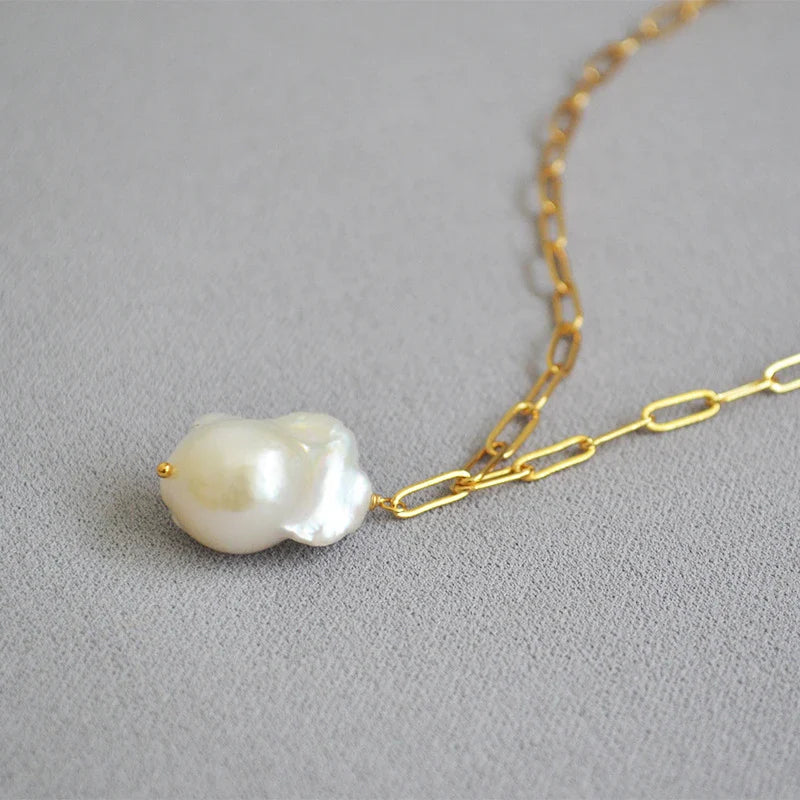 Elegant freshwater pearl necklace with a unique fish tail-shaped pendant and a delicate O-shaped chain